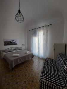 马里迪莫Struttura Le Gemme的白色的客房设有床和窗户。