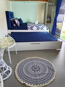 Casa LiLa Tiny Stay & Pool Kota Bharu,free wifi,free parking的一间卧室配有一张带蓝色被子和地毯的床。