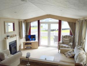 TunstallSand Le Mere Holiday Village Caravan hire的带沙发和电视的客厅