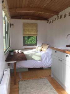黑尔斯沃思The Warren - Cosy Shepherds Hut in beautiful wild meadow的一间小卧室,配有床和窗户