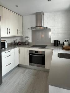 塔里法TarifaMiCasa Mar Tirreno的厨房配有白色橱柜和炉灶烤箱。