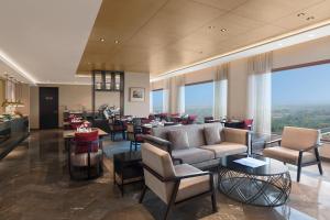 新德里新德里玛玉尔豪尔诺伊达皇冠假日酒店的酒店大堂配有沙发、椅子和桌子