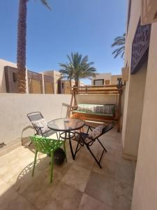 赫尔格达Nayah Stays, Beautiful 3-bedroom vacation home with lovely pool的阳台的天井配有桌椅