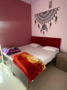 瓦拉纳西Banaras Guest House的一间小卧室,配有一张红色床头板的床