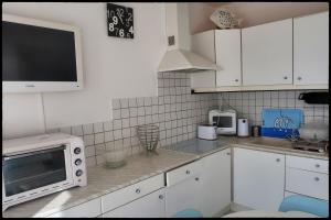 圣特罗让莱班Le plongeoir的厨房配有白色橱柜和台面上的微波炉