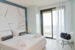 里乔内The Promenade Luxury Wellness Hotel的一间卧室设有两张床和大窗户