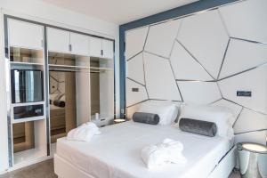 里乔内The Promenade Luxury Wellness Hotel的卧室配有白色床和毛巾
