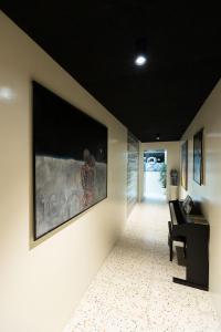 博尔扎诺Pepper Lounge & Suite的走廊上设有钢琴和墙上的大画