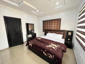 拉各斯CampDavid Luxury Apartments Ajao Estate Airport Road Lagos 0 8 1 4 0 0 1 3 1 2 5的一间卧室设有一张床和一个黑色的门