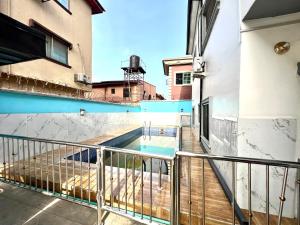 拉各斯CampDavid Luxury Apartments Ajao Estate Airport Road Lagos 0 8 1 4 0 0 1 3 1 2 5的大楼内带游泳池的阳台