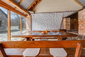 GračacSOKOL - Secret forest house的窗户客房内的木桌和长凳