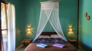 吉利阿尔UTOPIA的一间卧室配有一张天蓬床和两张毛巾