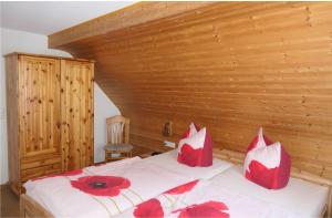 Rohrbach4 Sterne Ferienwohnung Sommerberg的一间卧室配有一张带红色枕头的床