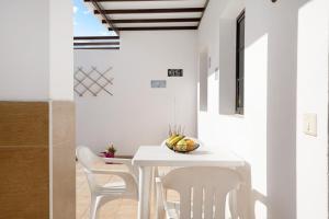 宏达海滩Casa Candido 2的白色的用餐室配有白色的桌椅