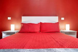 宏达海滩Casa Candido 2的红色卧室配有红色床单和枕头。