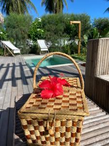 福廷Tiki Pool's Bungalows的一只装有红花的柳条篮子