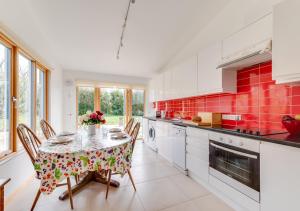 LymingeApple Barn的厨房配有桌椅和红色瓷砖