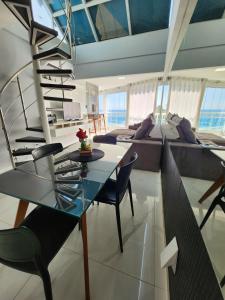 萨尔瓦多Cobertura em Ondina的一间带玻璃桌和螺旋楼梯的客厅