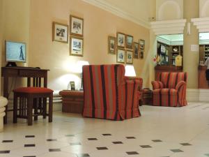 特雷利乌加利西亚酒店的大堂设有两把椅子、一张桌子和一架钢琴