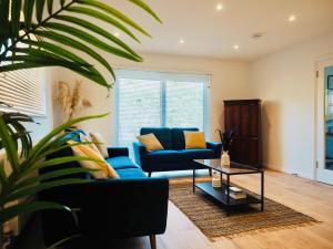 法恩伯勒Luxurious Detached Bungalow with Private Parking的客厅配有蓝色的沙发和桌子
