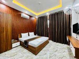 河静THÀNH HỒNG HOTEL的一间卧室配有一张床和一台电视