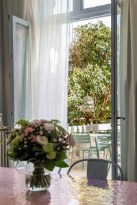 阿尔勒Maison Douce Arles的花瓶坐在窗前的桌子上