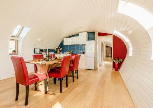 LymingeBumble Barn的厨房以及带桌子和红色椅子的用餐室。