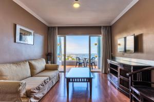 圣乌尔苏拉Coral La Quinta Park Suites的客厅配有沙发和桌子