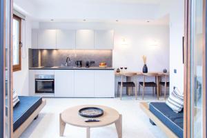 阿齐亚佩拉加ELMARAL living experience "Adults Only"的厨房以及带白色橱柜和桌子的客厅。