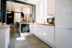 阿尔比L'Oasis - Charme et confort au centre-ville的厨房配有白色橱柜和台面