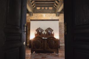 克雷莫纳Foresteria Palazzo Guazzoni Zaccaria的砖墙间里的一张木床