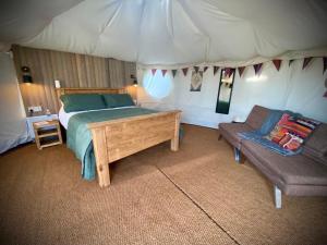 SykehouseBetween Rivers Camping @ The Old George Inn的一间卧室配有一张床,一张沙发位于帐篷内