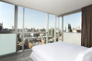纽约利文顿酒店的卧室设有白色的床和大窗户