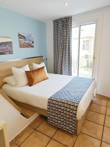 卡西斯HOTEL DES CALANQUES的一间卧室设有一张大床和窗户