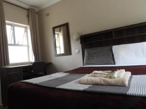 哈拉雷2 Bed Apt with en-suite and kitchenette - 2066的一间卧室配有一张床,上面有两条毛巾