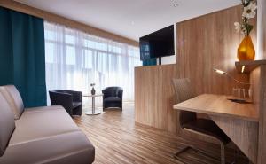 施魏希Hotel zum Stern的客厅配有沙发和书桌及电视