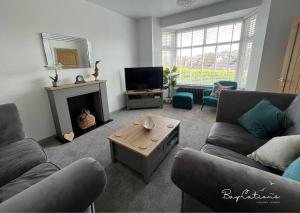 布里克瑟姆Stylish Brixham home, sleeps 7, parking & garden的客厅设有两张沙发和一个壁炉