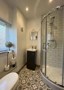 布里克瑟姆Stylish Brixham home, sleeps 7, parking & garden的带淋浴、卫生间和盥洗盆的浴室