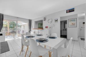 图卢兹Prat d'Albis - Appt avec terrasse的白色的用餐室配有白色的桌椅