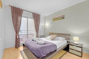 图卢兹Prat d'Albis - Appt avec terrasse的一间卧室配有一张大床和紫色毯子