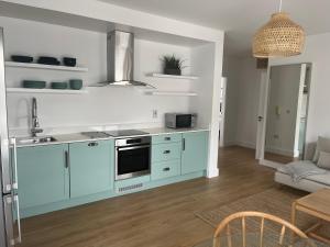 恩尼斯科西2 Bedroom Apartment Central Town Location的厨房配有蓝色橱柜和炉灶烤箱。