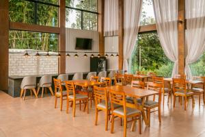 帕尔杜河畔圣若泽Pousada Terra Rossa的餐厅设有木桌、椅子和窗户。