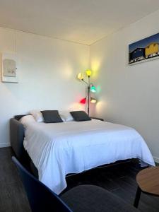 滨海苏拉克Appartement vue mer的卧室配有白色的床和桌子