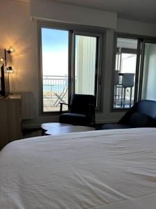 滨海苏拉克Appartement vue mer的一间卧室配有一张床、两把椅子和窗户