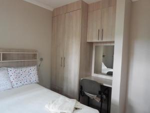 哈拉雷2 bedroomed apartment with en-suite and kitchenette - 2069的一间卧室配有床、水槽和镜子