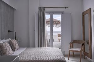 卡马利马克里斯海滩公寓式酒店的一间卧室配有一张床,享有海景