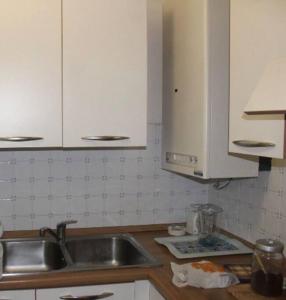 卡帕尔比奥Affittasi a Capalbio per un minimo di 5 notti的厨房配有水槽和白色橱柜