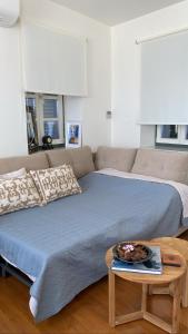 爱琴娜岛Naias Aegina, Sea-front apartment 95 sqm的一间卧室配有一张床、一张沙发和一张桌子