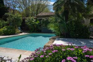 蒙彼利埃Oasis centre charme的一座鲜花盛开的庭院内的游泳池