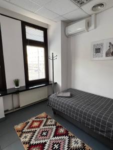 华沙Aleja "Solidarności"的客房设有床、地毯和窗户。